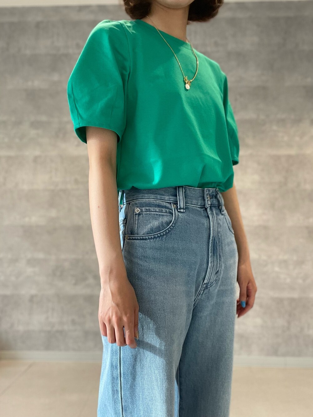 グレー系のTシャツ/カットソー、ブルー系のデニムパンツ、シルバー系のショルダーバッグを着用したレディースの春コーディネートの8枚目の写真