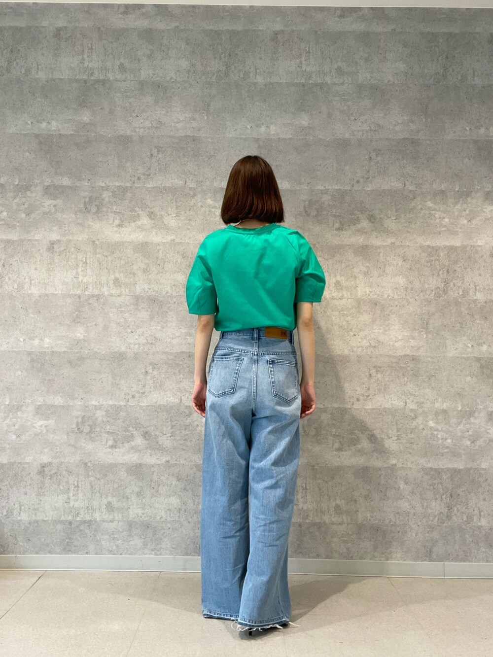 グレー系のTシャツ/カットソー、ブルー系のデニムパンツ、シルバー系のショルダーバッグを着用したレディースの春コーディネートの6枚目の写真