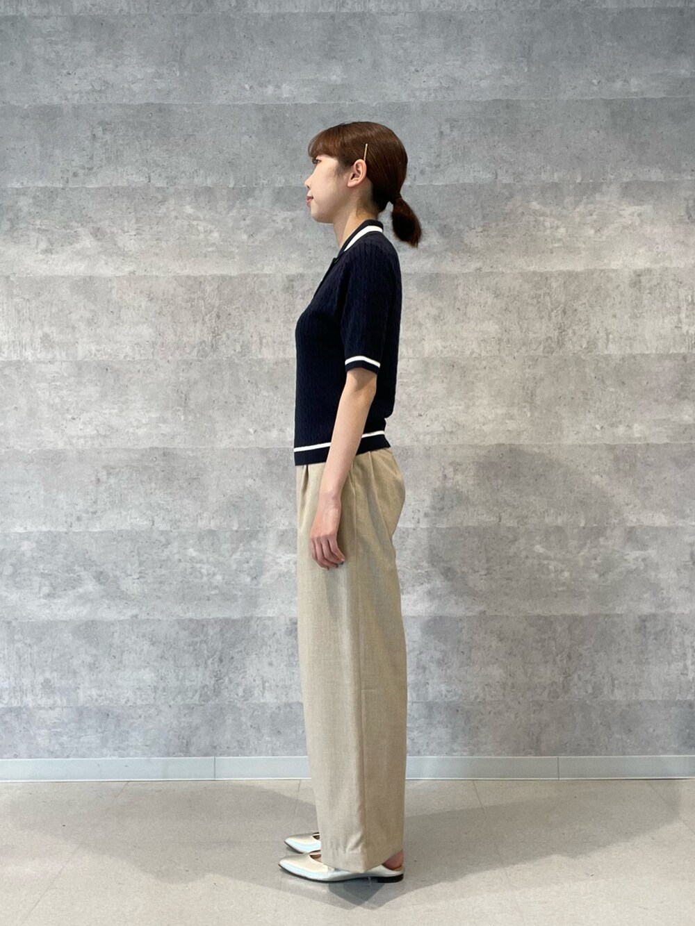 ブルー系のニット/セーター、ベージュ系のその他パンツ、ゴールド系のパンプスを着用したレディースの春コーディネートの3枚目の写真