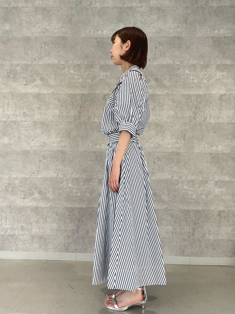 ホワイト系のシャツ/ブラウス、ホワイト系のスカート、シルバー系のサンダルを着用したレディースの夏コーディネートの3枚目の写真