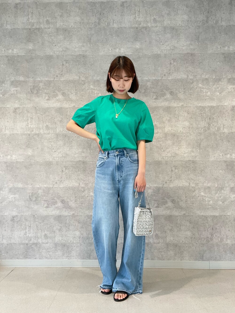 グレー系のTシャツ/カットソー、ブルー系のデニムパンツ、シルバー系のショルダーバッグを着用したレディースの春コーディネートの2枚目の写真