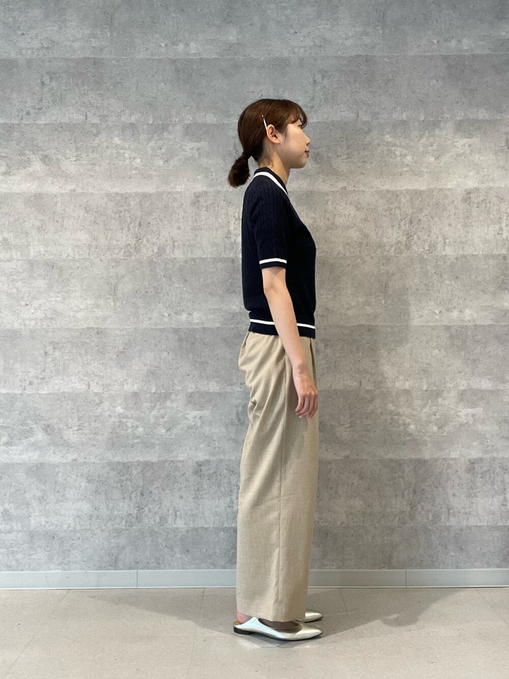 ブルー系のニット/セーター、ベージュ系のその他パンツ、ゴールド系のパンプスを着用したレディースの春コーディネートの4枚目の写真