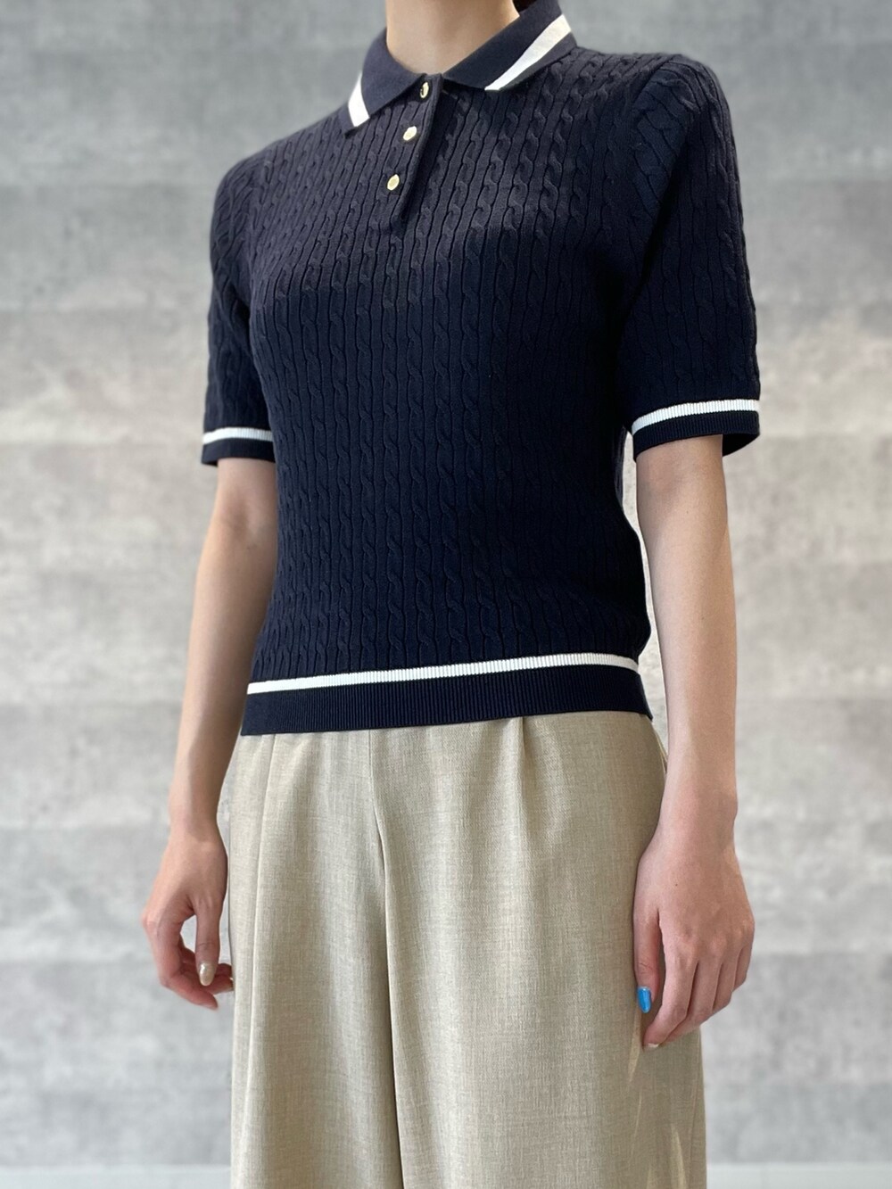 ブルー系のニット/セーター、ベージュ系のその他パンツ、ゴールド系のパンプスを着用したレディースの春コーディネートの6枚目の写真