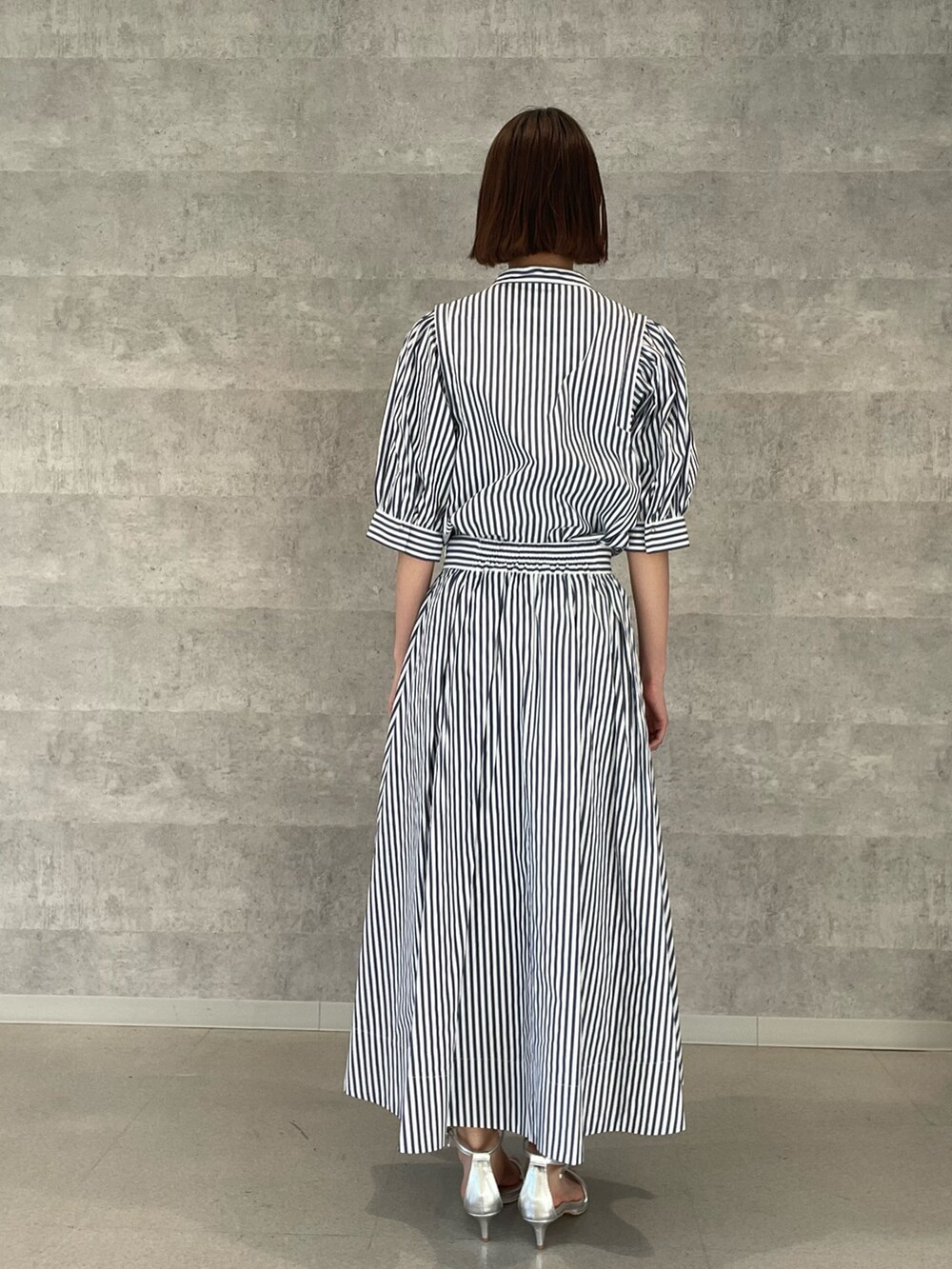 ホワイト系のシャツ/ブラウス、ホワイト系のスカート、シルバー系のサンダルを着用したレディースの夏コーディネートの5枚目の写真