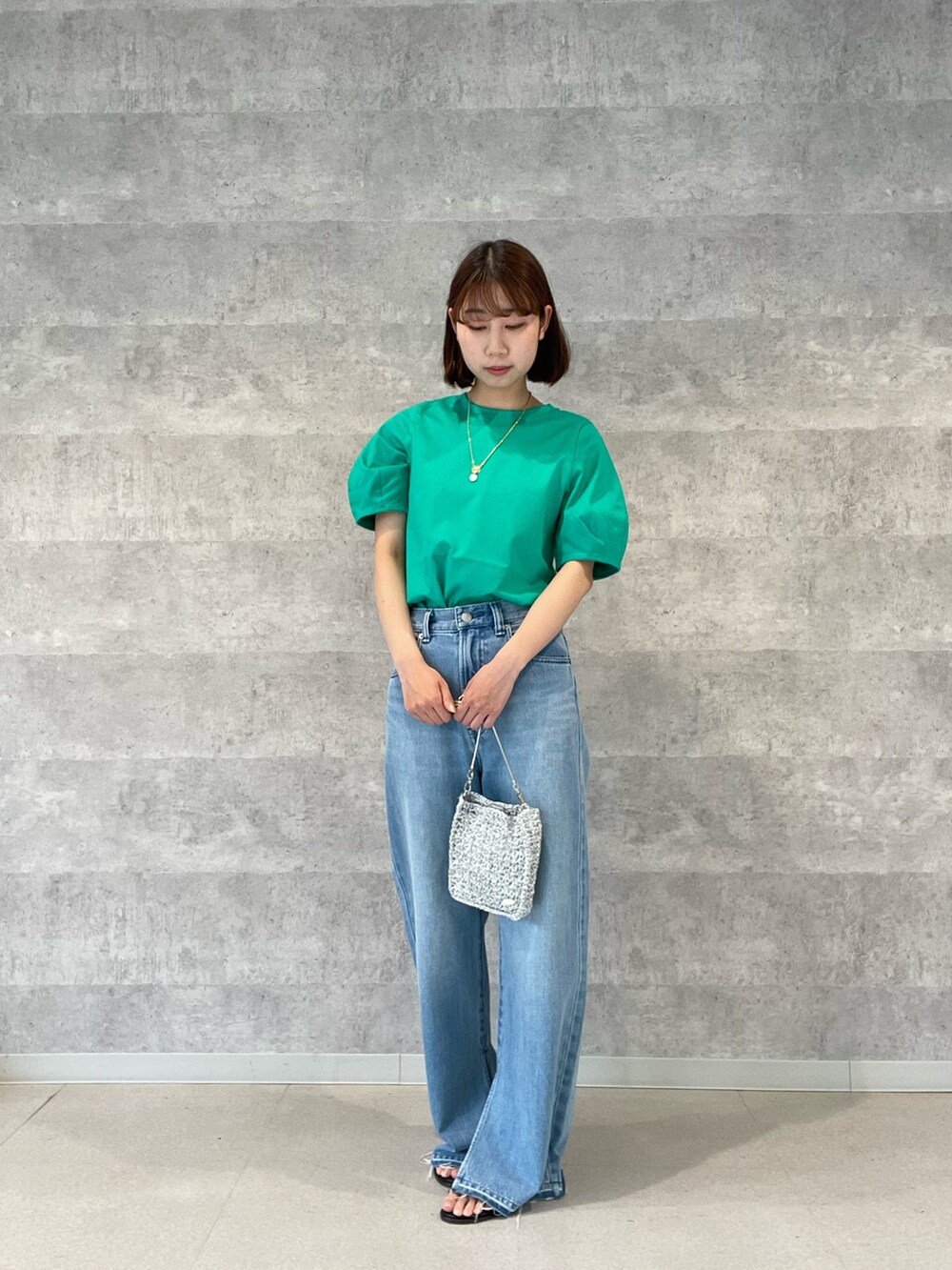 グレー系のTシャツ/カットソー、ブルー系のデニムパンツ、シルバー系のショルダーバッグを着用したレディースの春コーディネートの3枚目の写真