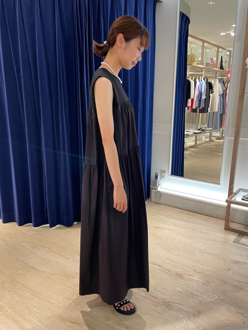 ブラック系のサンダル、ブラック系のワンピース、ホワイト系のネックレスを着用したレディースの夏コーディネートの4枚目の写真