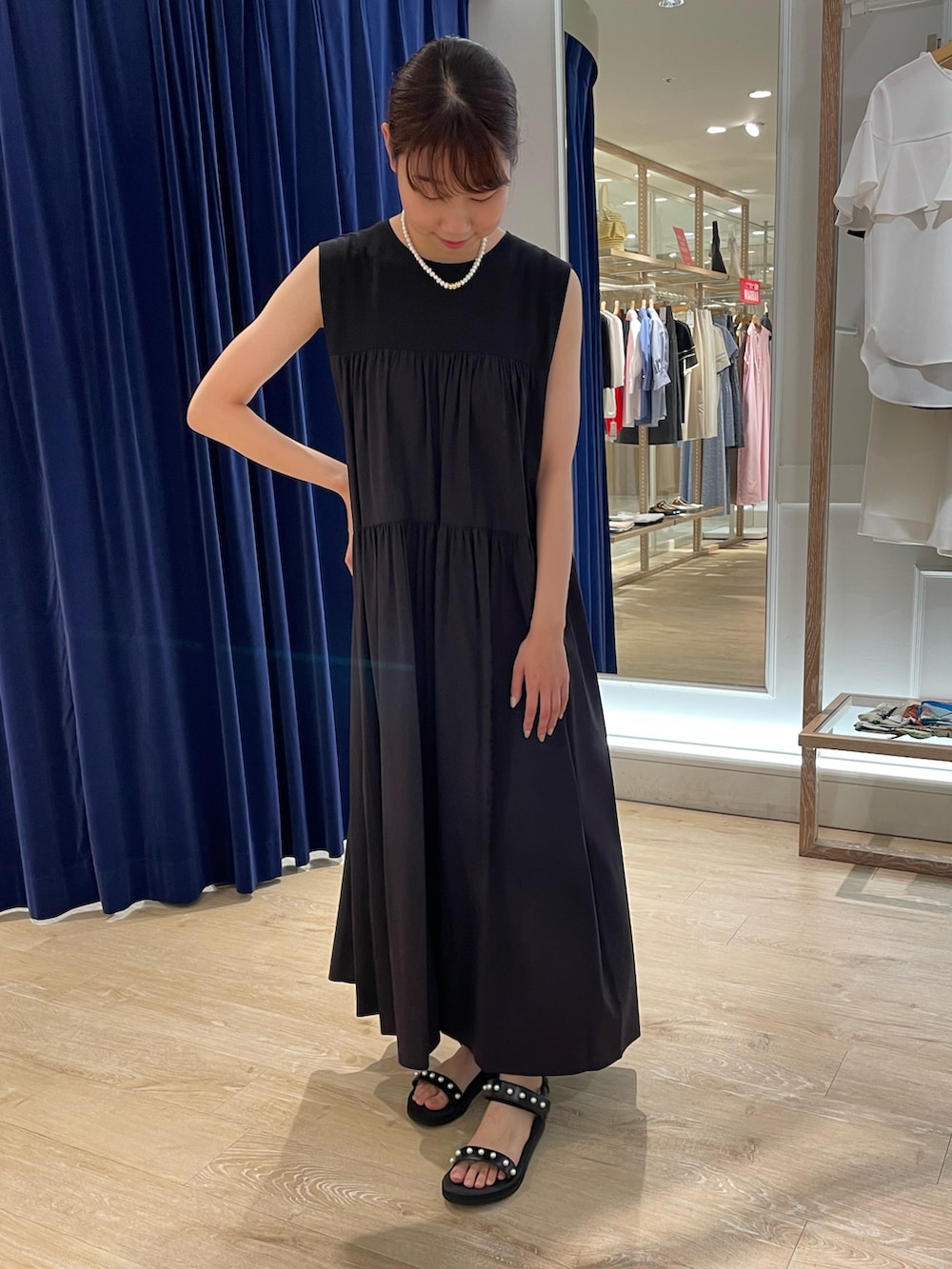 ブラック系のサンダル、ブラック系のワンピース、ホワイト系のネックレスを着用したレディースの夏コーディネートの3枚目の写真