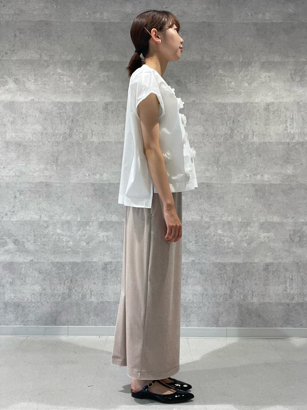 ホワイト系のシャツ/ブラウス、ベージュ系のスカート、ブラック系のショルダーバッグを着用したレディースの夏コーディネートの6枚目の写真