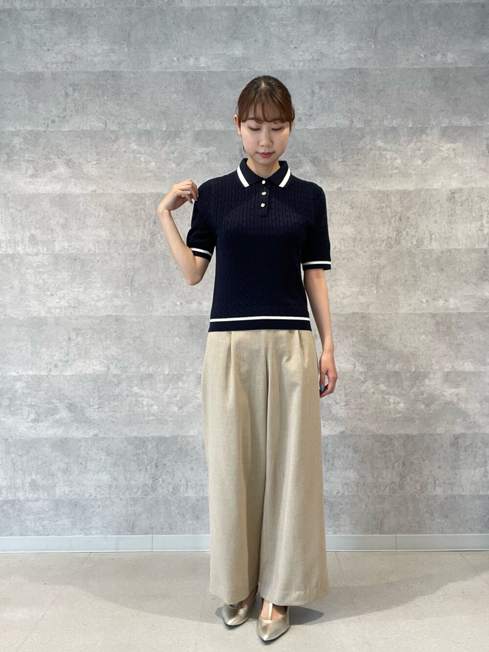 ブルー系のニット/セーター、ベージュ系のその他パンツ、ゴールド系のパンプスを着用したレディースの春コーディネートの2枚目の写真