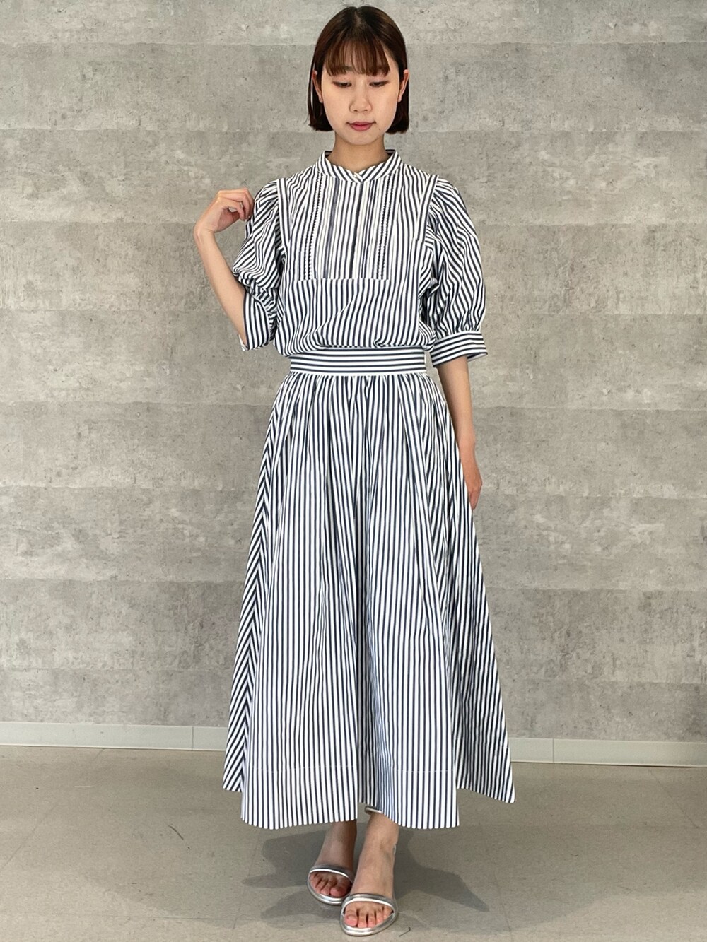 ホワイト系のシャツ/ブラウス、ホワイト系のスカート、シルバー系のサンダルを着用したレディースの夏コーディネートの2枚目の写真