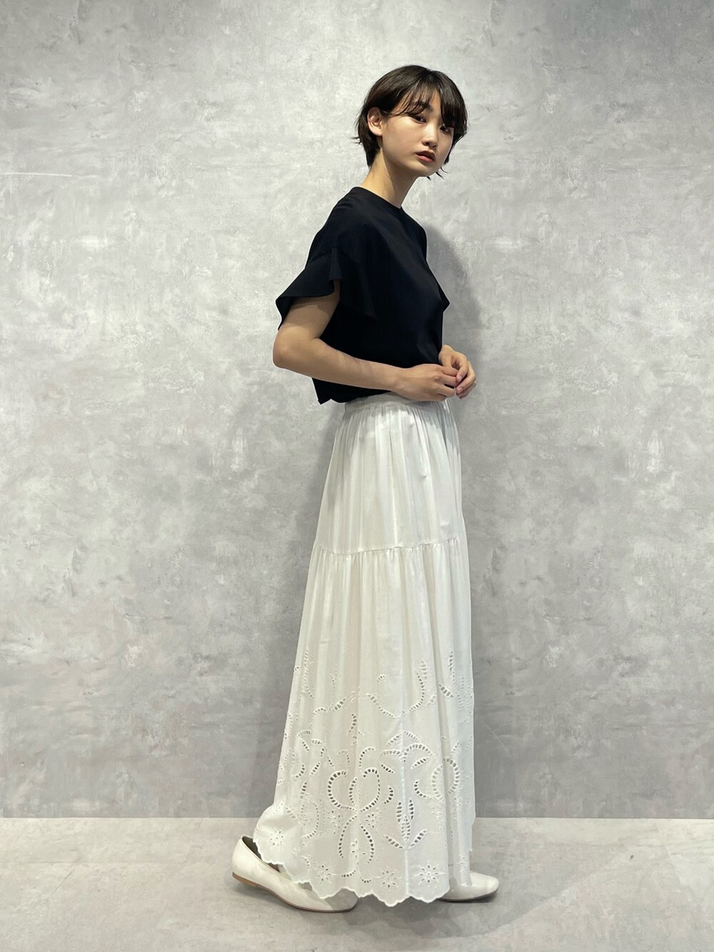 ブラック系のTシャツ/カットソー、ホワイト系のスカートを着用したレディースの秋コーディネートの2枚目の写真