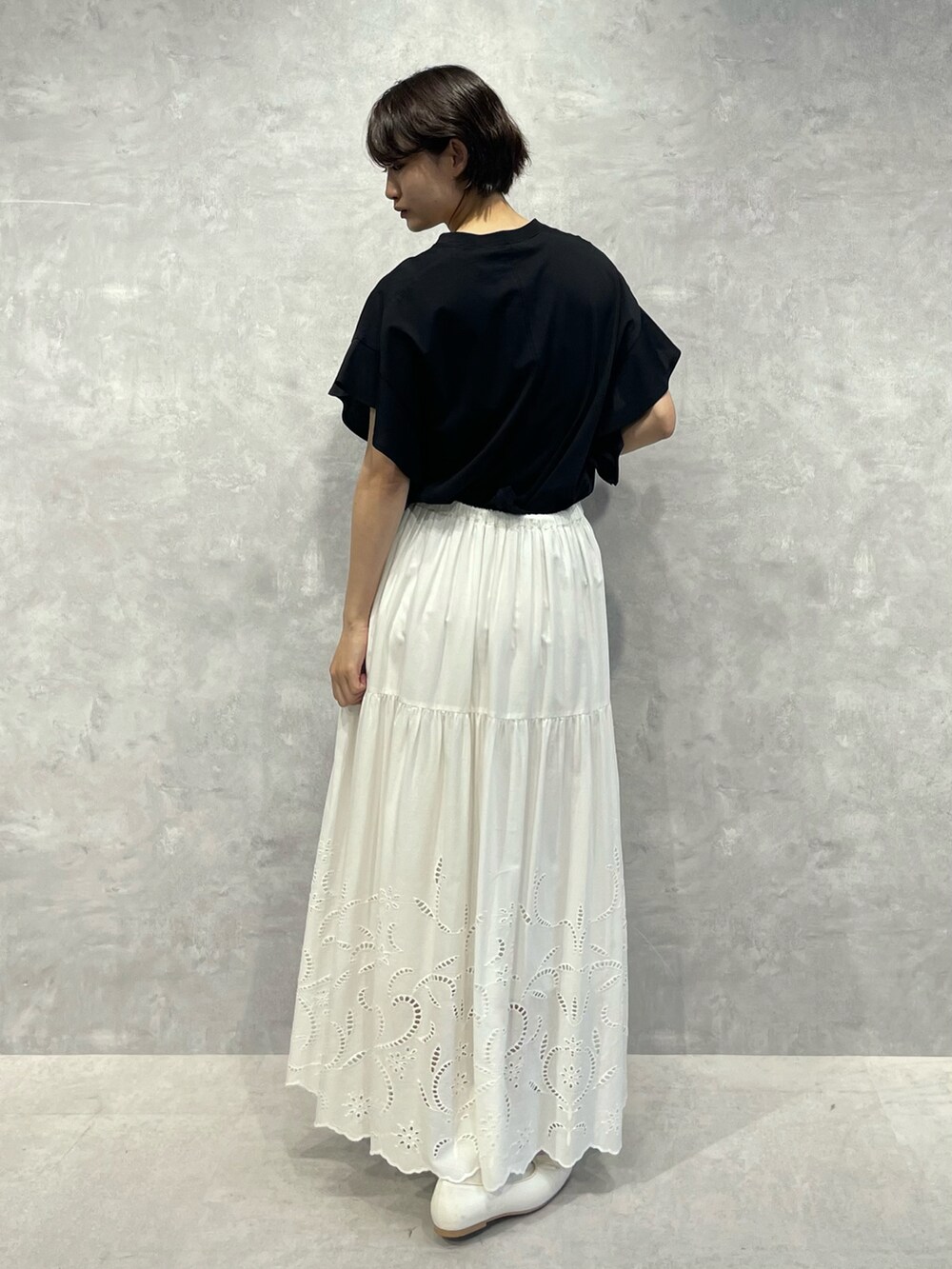 ブラック系のTシャツ/カットソー、ホワイト系のスカートを着用したレディースの秋コーディネートの3枚目の写真