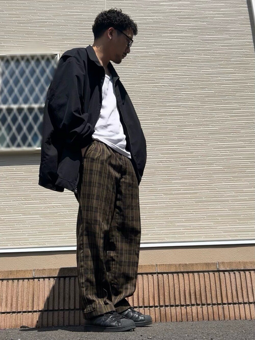 ブラック系のスニーカーを着用したメンズの春コーディネートの2枚目の写真
