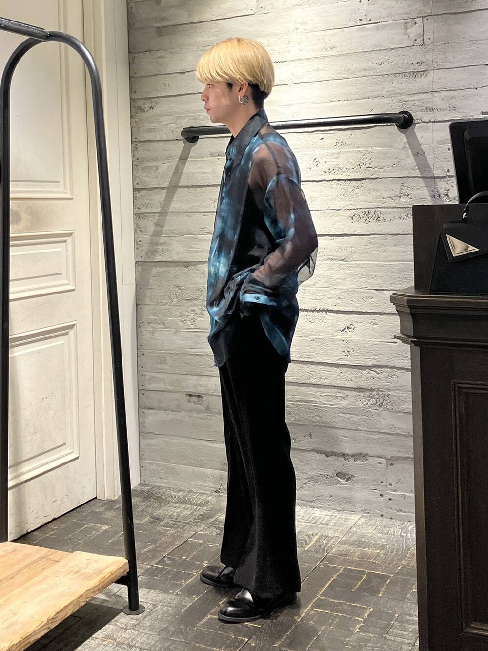 ブラック系のスラックス、ブラック系のドレスシューズ、ブルー系のシャツ/ブラウスを着用したメンズの春コーディネートの2枚目の写真