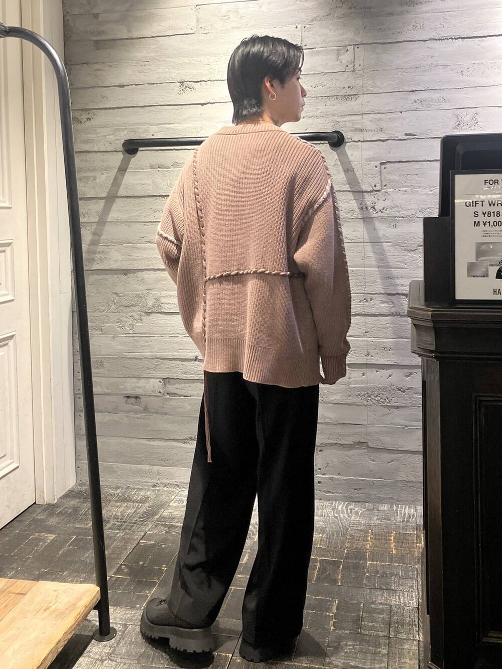 ブラック系のスラックス、ホワイト系のスウェット、ブラック系のドレスシューズを着用したメンズの冬コーディネートの3枚目の写真