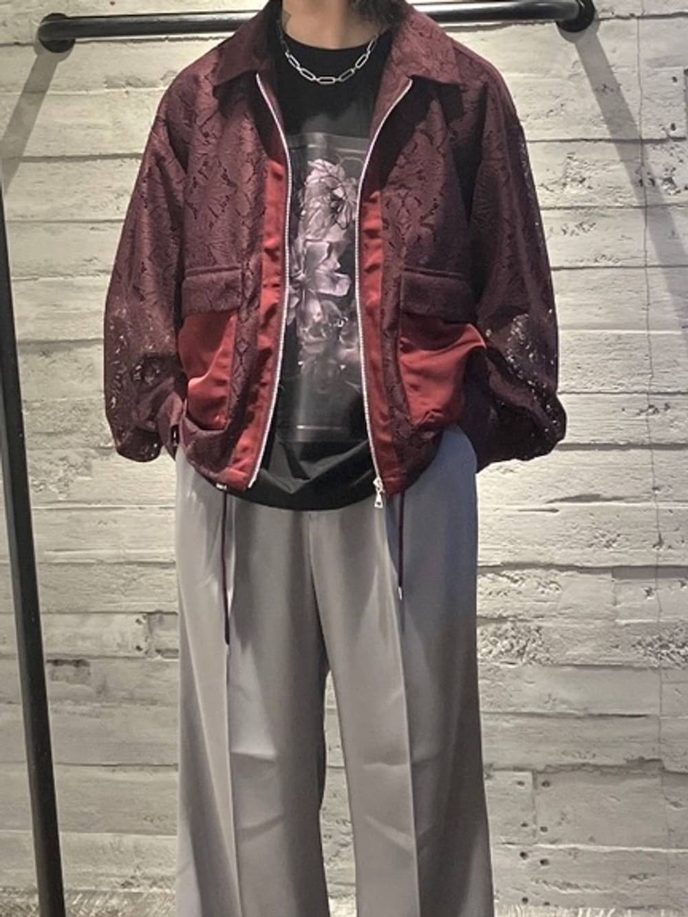 グレー系のスラックス、ブラック系のドレスシューズ、レッド系のブルゾンを着用したメンズの夏コーディネートの2枚目の写真