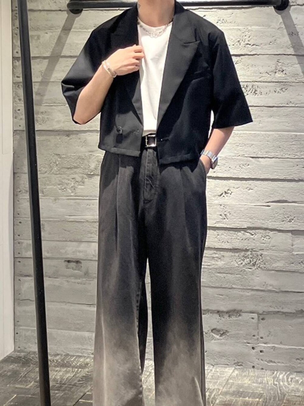 ブラック系のデニムパンツ、ホワイト系のTシャツ/カットソー、ブラック系のドレスシューズを着用したメンズの夏コーディネートの2枚目の写真