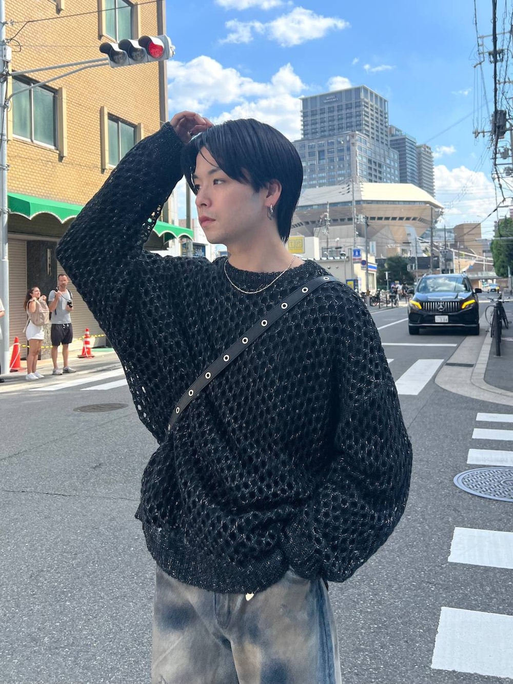 ブラック系のドレスシューズ、ブルー系のデニムパンツ、ブラック系のニット/セーターを着用したメンズの秋コーディネートの2枚目の写真