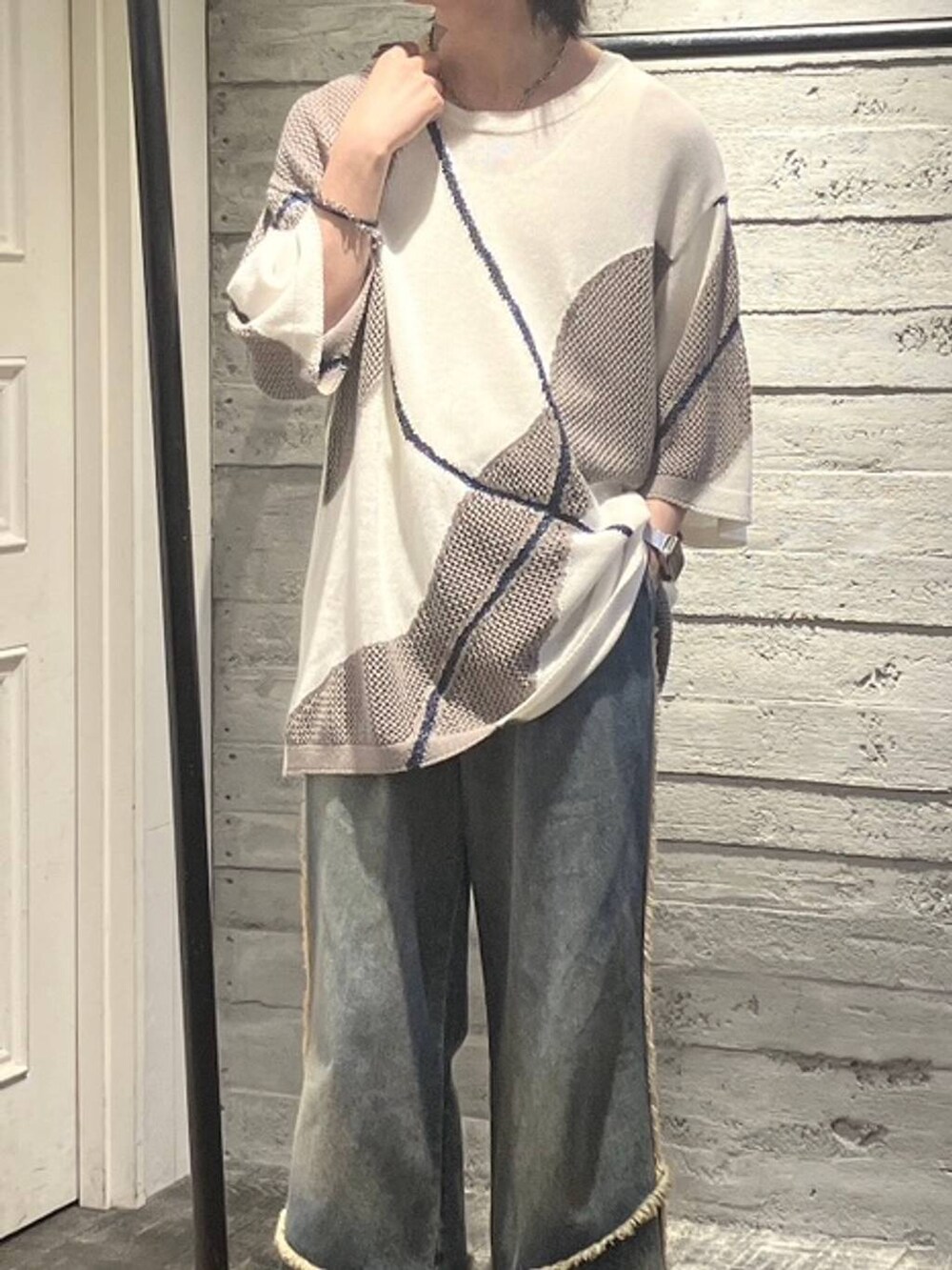 ブラック系のスニーカー、オレンジ系のデニムパンツ、ホワイト系のニット/セーターを着用したメンズの夏コーディネートの2枚目の写真