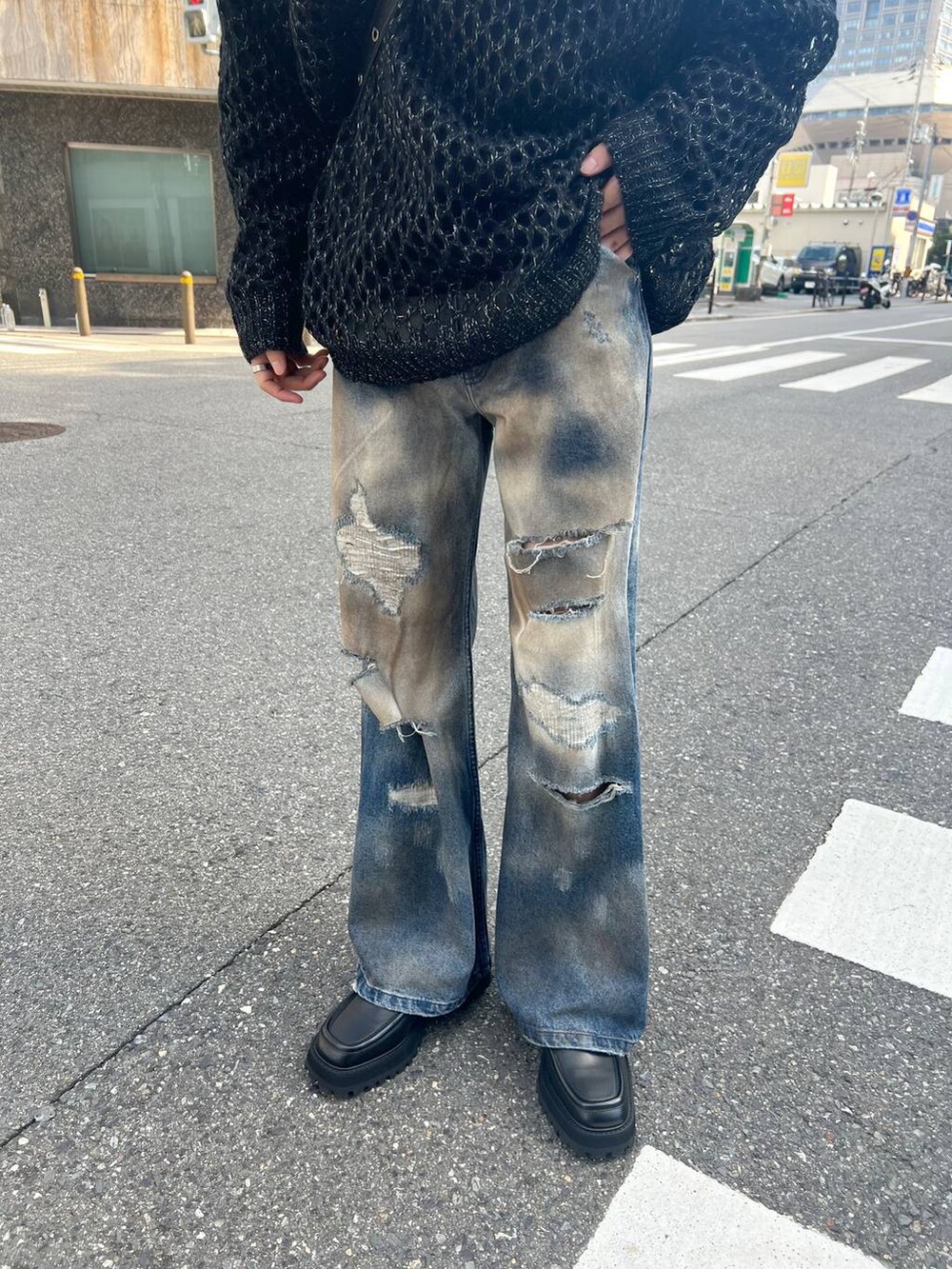 ブラック系のドレスシューズ、ブルー系のデニムパンツ、ブラック系のニット/セーターを着用したメンズの秋コーディネートの3枚目の写真