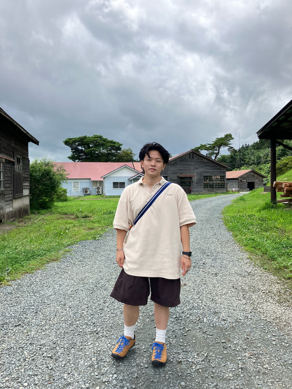 オレンジ系のドラムバッグ、オレンジ系のスニーカー、ブラウン系のその他パンツを着用したメンズの夏コーディネートの3枚目の写真