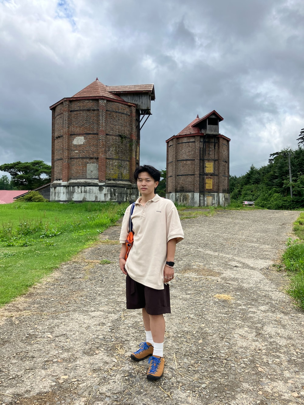 オレンジ系のドラムバッグ、オレンジ系のスニーカー、ブラウン系のその他パンツを着用したメンズの夏コーディネートの2枚目の写真