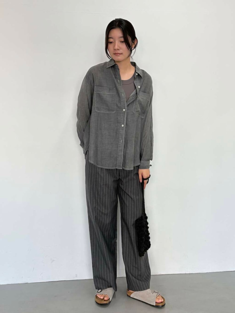 ブラック系のショルダーバッグ、グレー系のその他パンツ、ブラック系のシャツ/ブラウスを着用したレディースの夏コーディネートの3枚目の写真