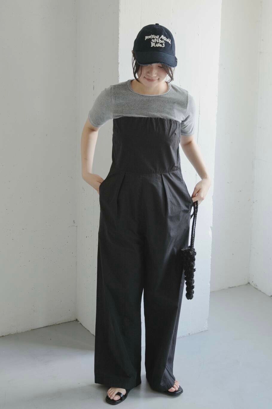 ブラック系のサンダル、ブルー系のキャップを着用したレディースの夏コーディネートの2枚目の写真