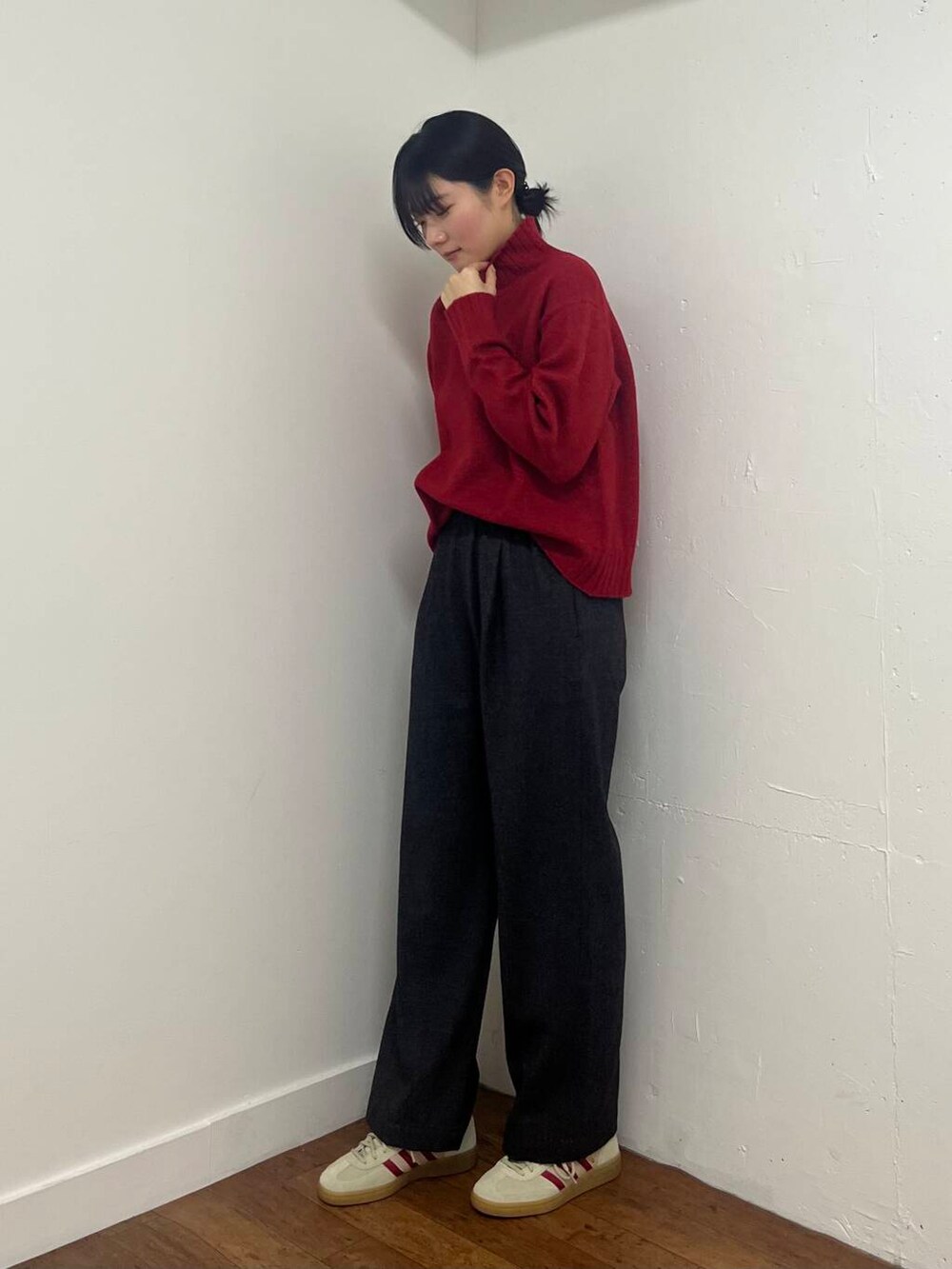 グレー系のその他パンツ、ホワイト系のスニーカー、レッド系のニット/セーターを着用したレディースの冬コーディネートの3枚目の写真