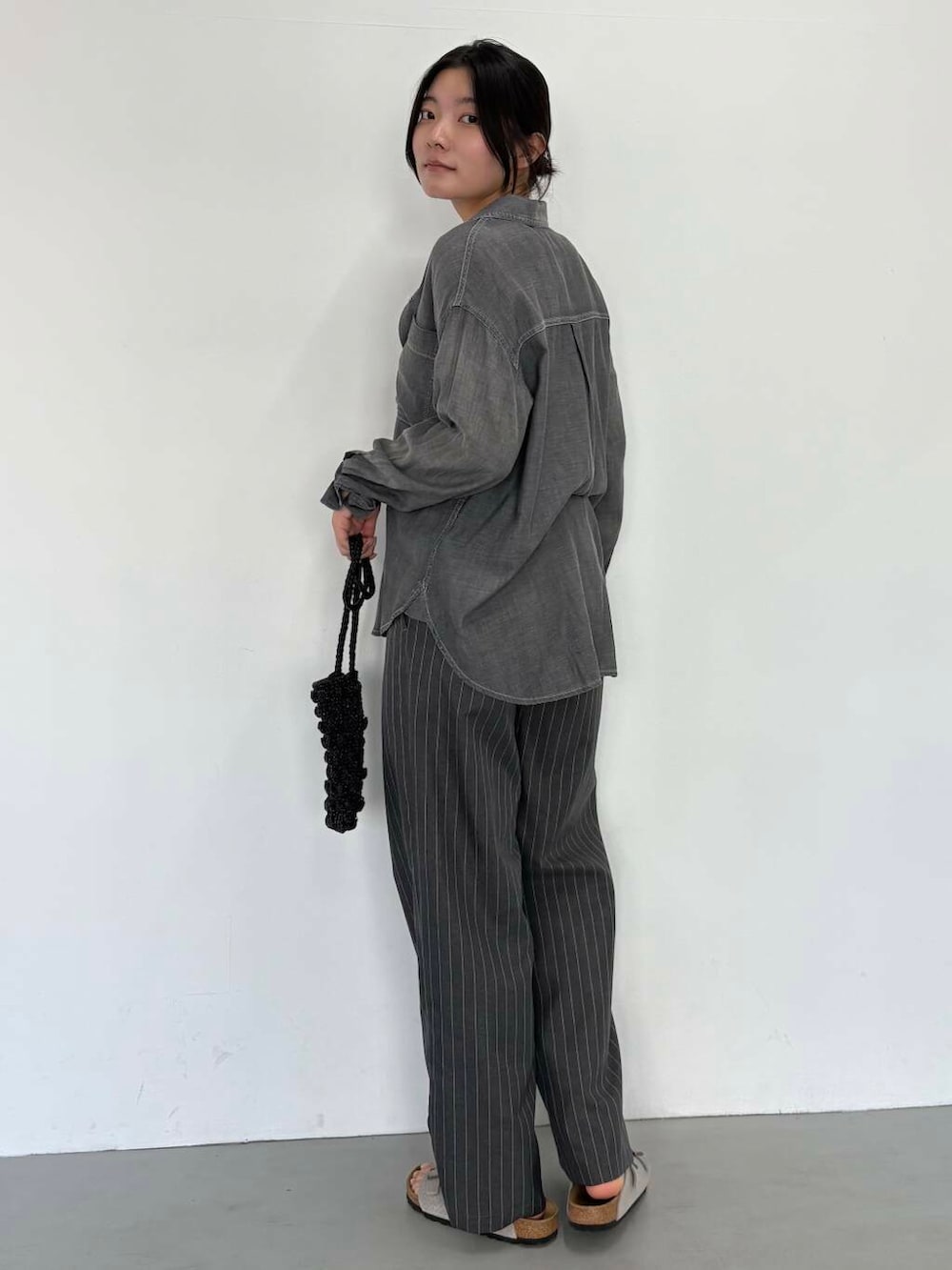 ブラック系のショルダーバッグ、グレー系のその他パンツ、ブラック系のシャツ/ブラウスを着用したレディースの夏コーディネートの4枚目の写真