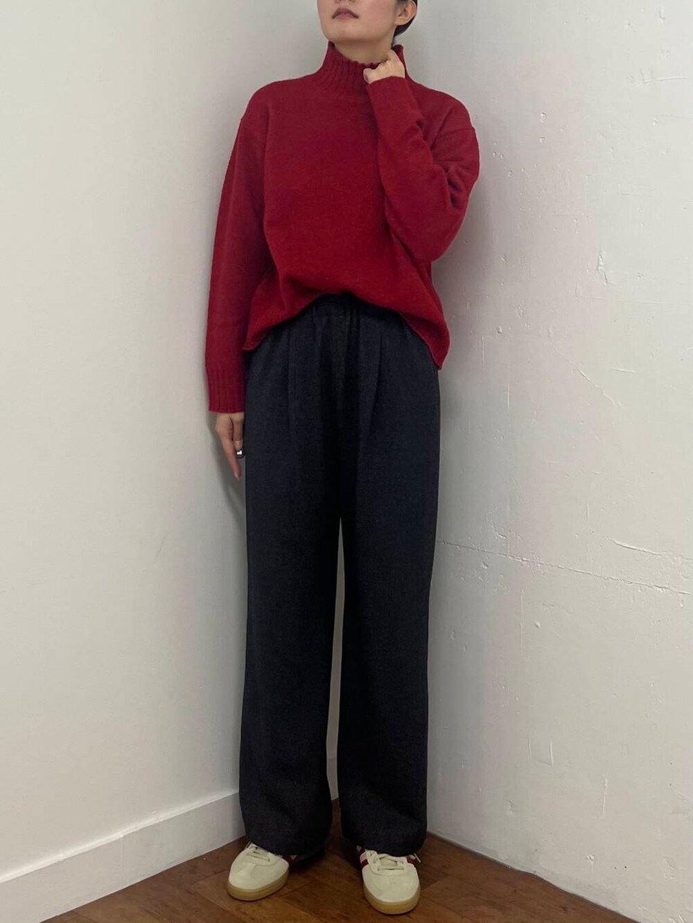 グレー系のその他パンツ、ホワイト系のスニーカー、レッド系のニット/セーターを着用したレディースの冬コーディネートの6枚目の写真