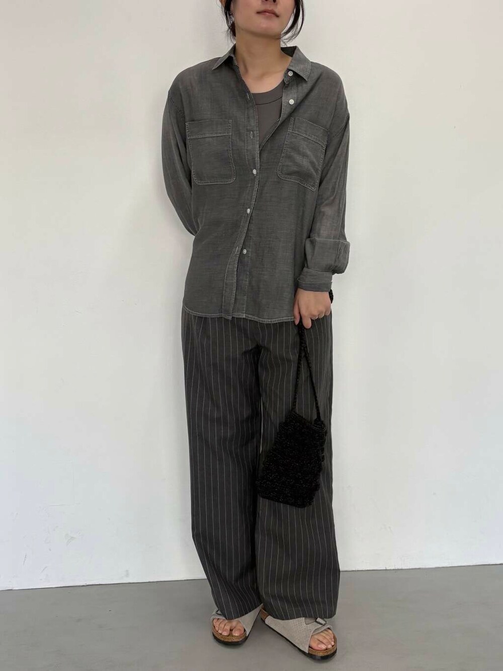 ブラック系のショルダーバッグ、グレー系のその他パンツ、ブラック系のシャツ/ブラウスを着用したレディースの夏コーディネートの6枚目の写真