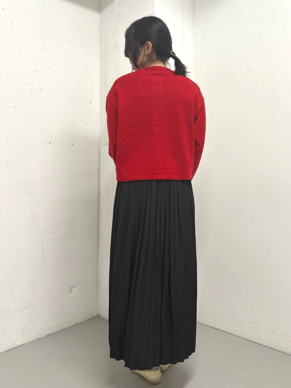 レッド系のカーディガン/ボレロ、ブラック系のスカートを着用したレディースの秋コーディネートの5枚目の写真