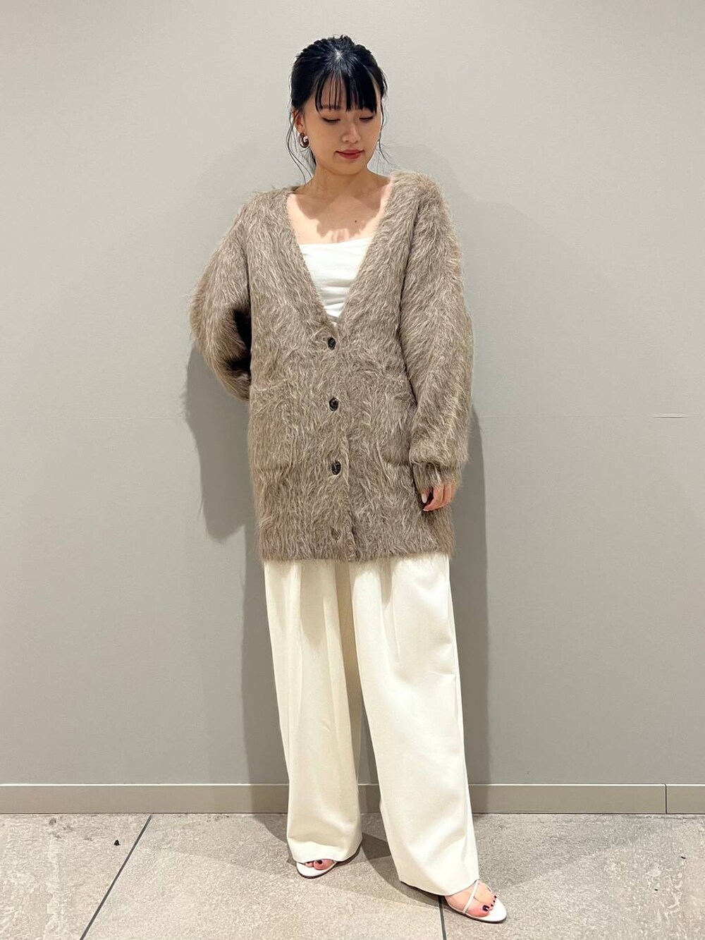 ベージュ系のカーディガン/ボレロ、ホワイト系のその他パンツを着用したレディースの秋コーディネートの2枚目の写真