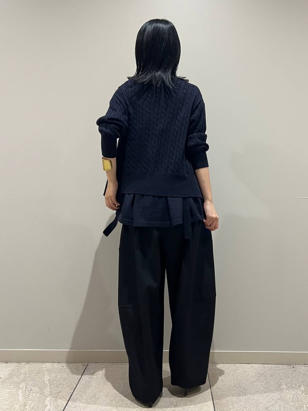 ブルー系のカーディガン/ボレロ、ブルー系のキャミソール、ブラック系のクラッチバッグを着用したレディースの秋コーディネートの4枚目の写真