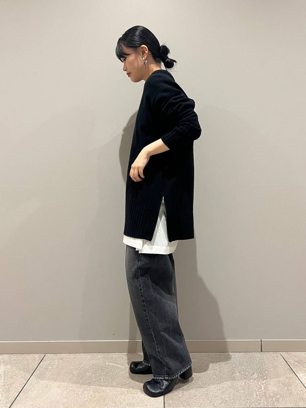 ブラック系のデニムパンツ、ブラック系のショルダーバッグ、ホワイト系のシャツ/ブラウスを着用したレディースの冬コーディネートの3枚目の写真