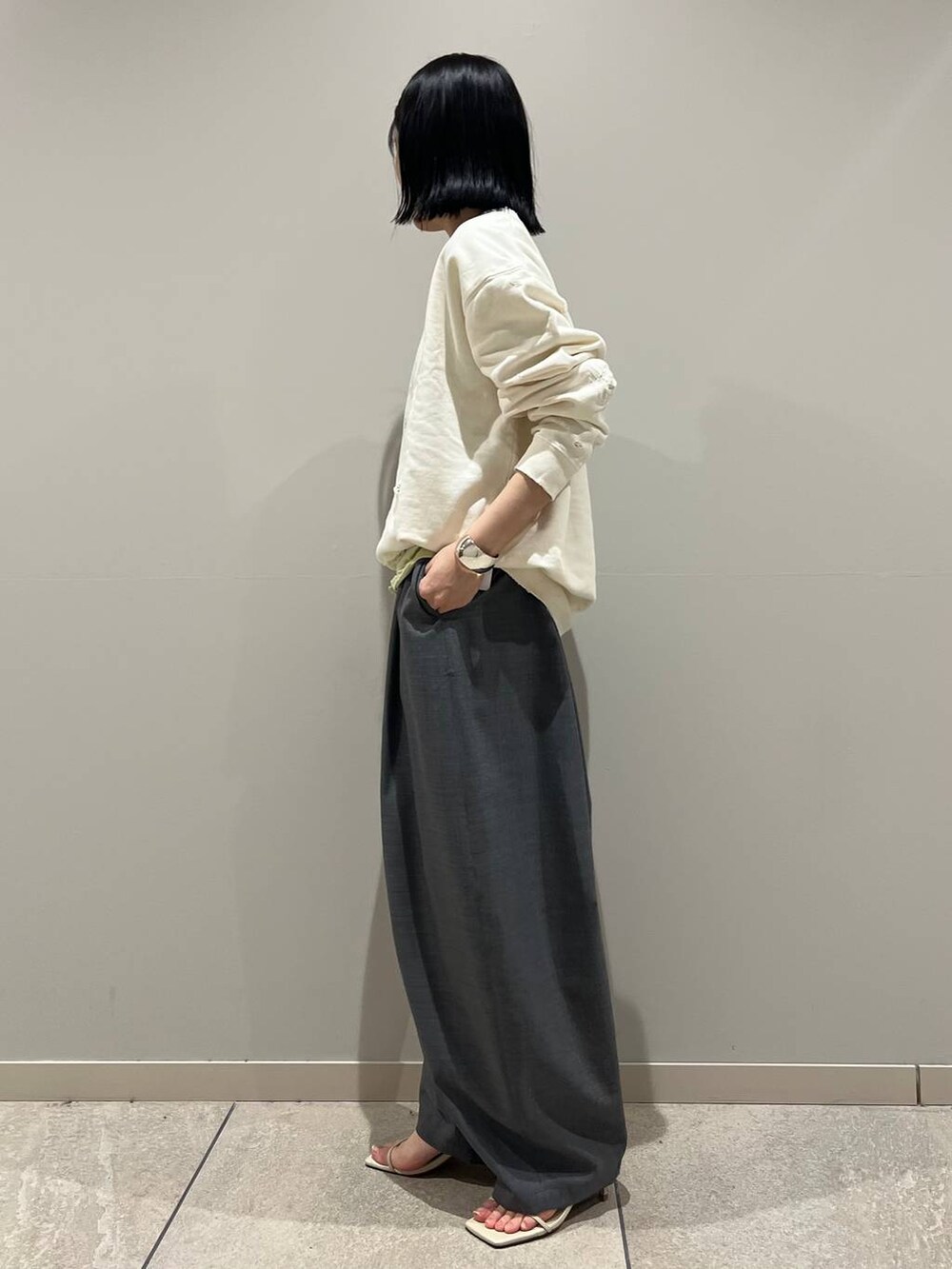 イエロー系のTシャツ/カットソー、グレー系のその他パンツ、シルバー系のバングル/リストバンドを着用したレディースの冬コーディネートの2枚目の写真