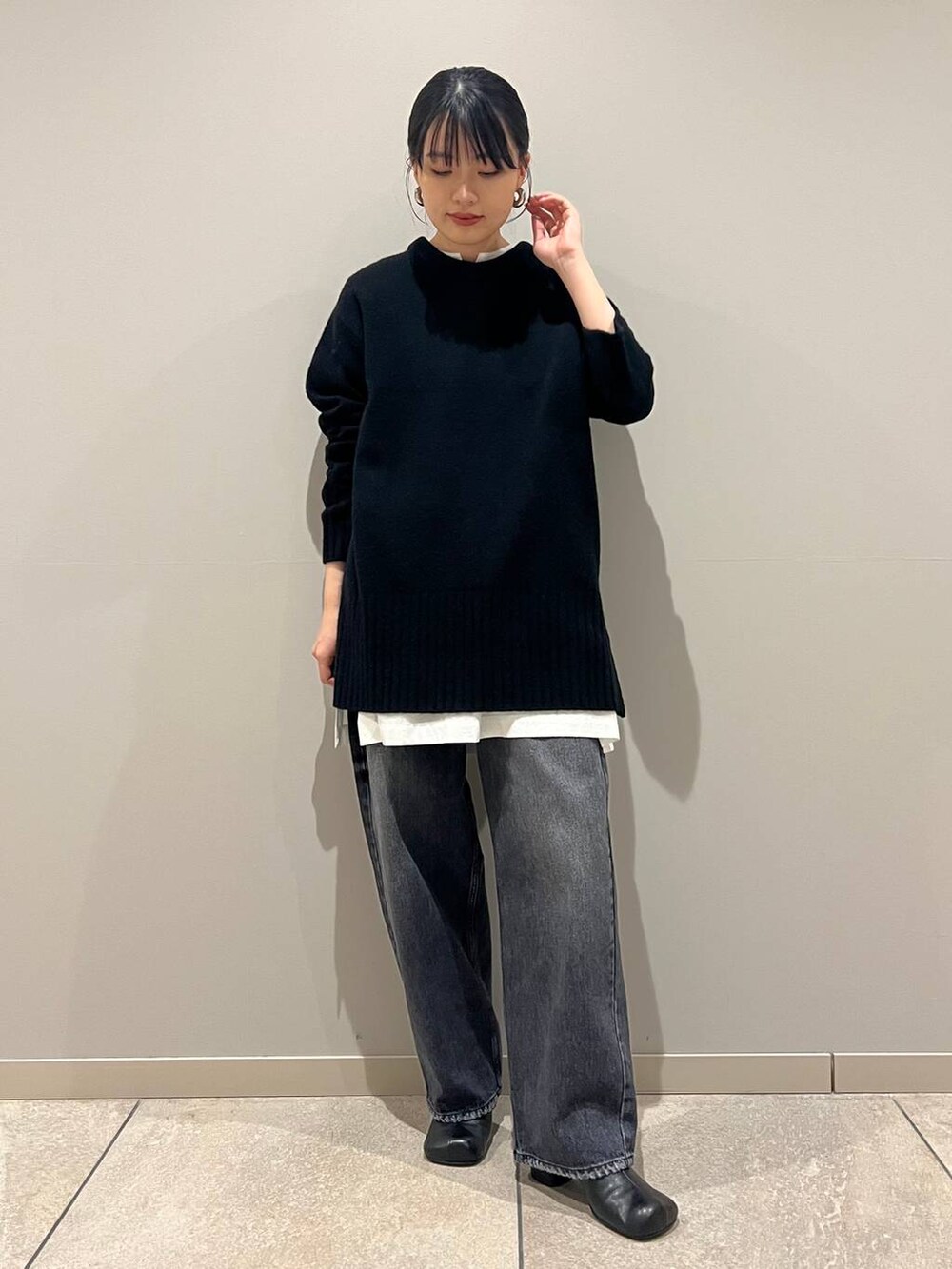 ブラック系のデニムパンツ、ブラック系のショルダーバッグ、ホワイト系のシャツ/ブラウスを着用したレディースの冬コーディネートの2枚目の写真