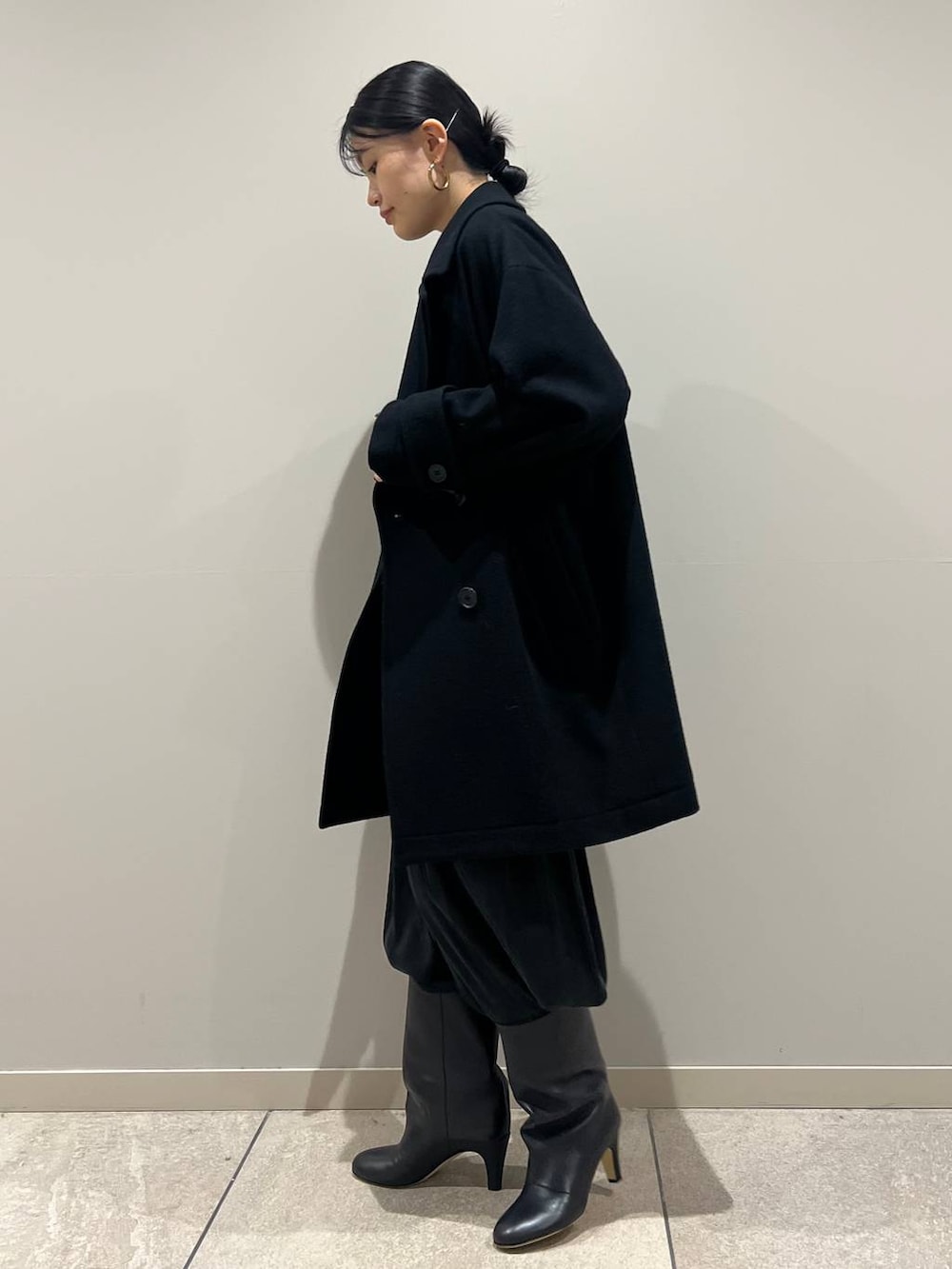 グレー系のニット/セーター、ブラック系のその他パンツ、ブラック系のピーコートを着用したレディースの冬コーディネートの2枚目の写真