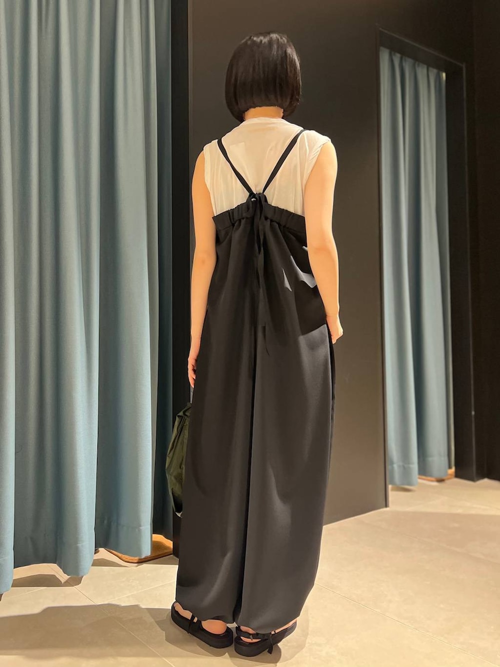 ホワイト系のTシャツ/カットソー、ブラック系のサンダル、ブラック系のつなぎ/オールインワンを着用したレディースの春コーディネートの3枚目の写真