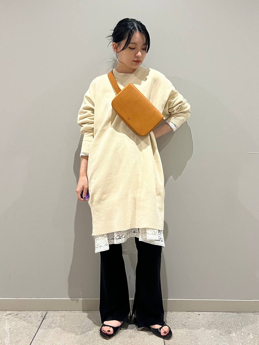 ブラック系のその他パンツ、ホワイト系のニット/セーター、イエロー系のボディバッグ/ウエストポーチを着用したレディースの夏コーディネートの2枚目の写真