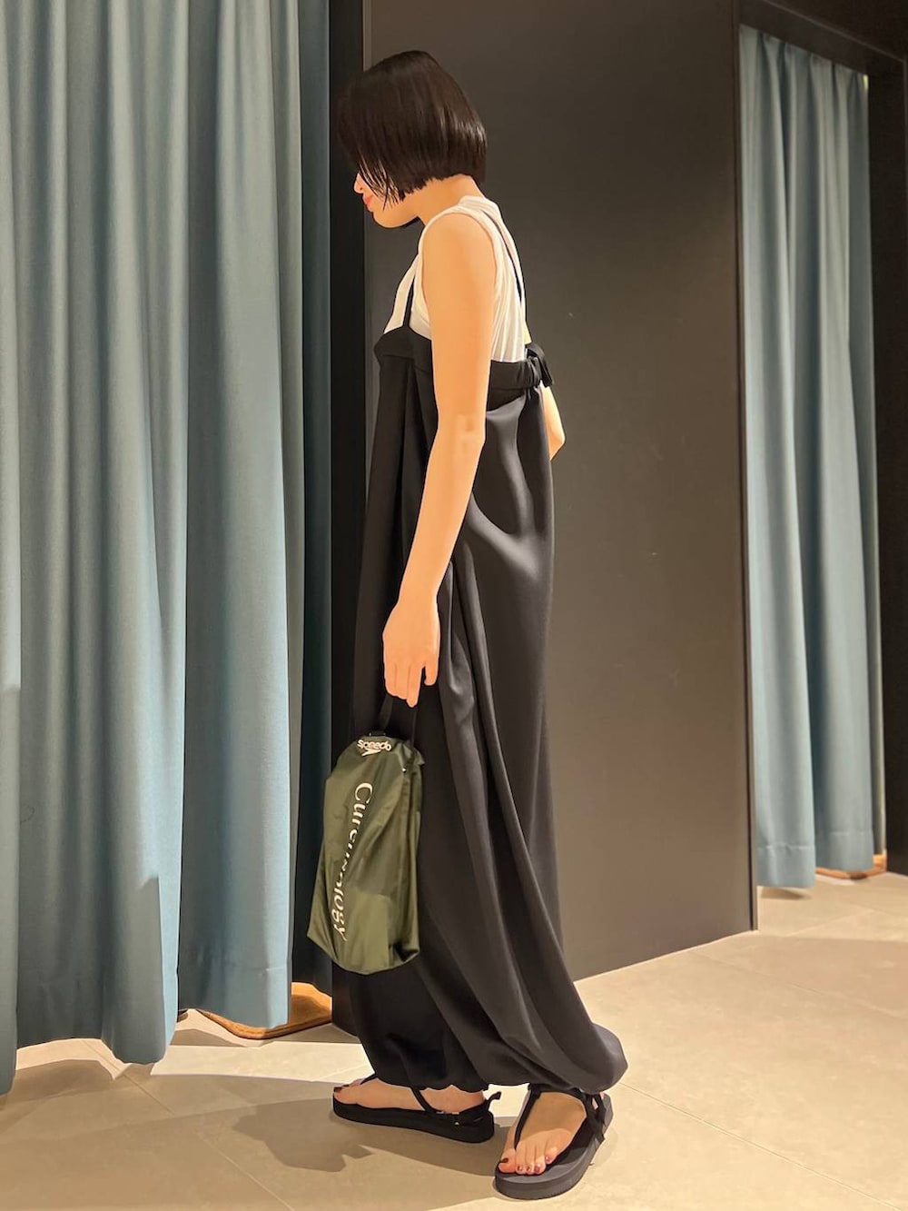 ホワイト系のTシャツ/カットソー、ブラック系のサンダル、ブラック系のつなぎ/オールインワンを着用したレディースの春コーディネートの2枚目の写真