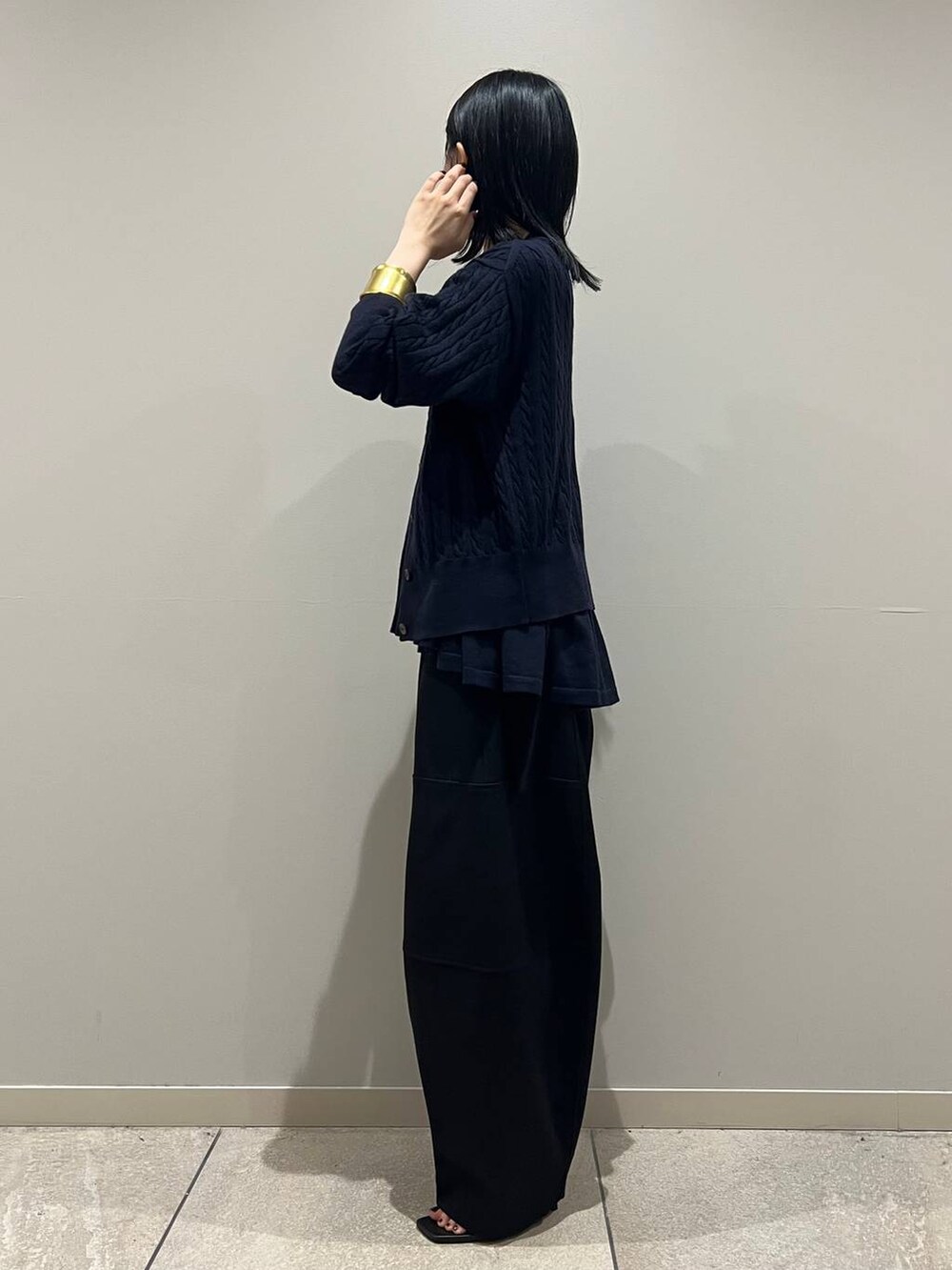 ブルー系のカーディガン/ボレロ、ブルー系のキャミソール、ブラック系のクラッチバッグを着用したレディースの秋コーディネートの3枚目の写真