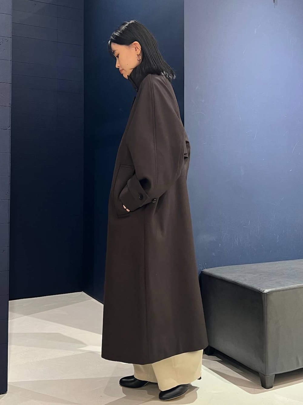 ホワイト系のその他パンツ、ブラウン系のトレンチコート、ホワイト系のニット/セーターを着用したレディースの秋コーディネートの2枚目の写真