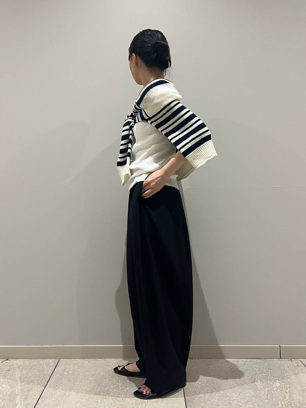 ホワイト系のタンクトップ、ブルー系のニット/セーター、ブラック系のその他パンツを着用したレディースの春コーディネートの3枚目の写真