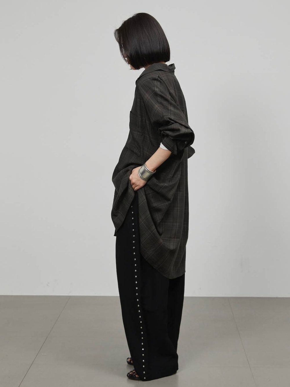 ホワイト系のTシャツ/カットソー、ブラック系のその他パンツ、グレー系のシャツ/ブラウスを着用したレディースの冬コーディネートの2枚目の写真