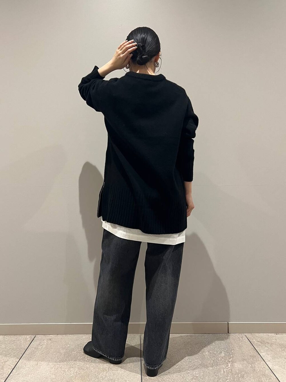 ブラック系のデニムパンツ、ブラック系のショルダーバッグ、ホワイト系のシャツ/ブラウスを着用したレディースの冬コーディネートの4枚目の写真