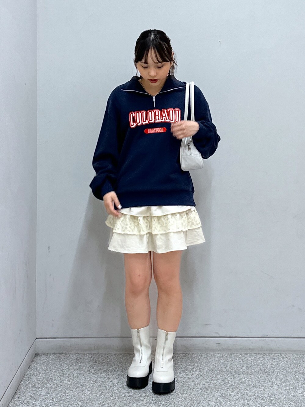 ブルー系のスウェット、ホワイト系のスカート、ホワイト系のトートバッグを着用したレディースの秋コーディネートの2枚目の写真