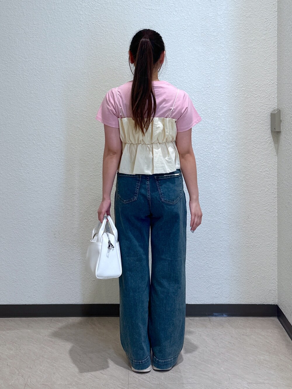 ピンク系のTシャツ/カットソー、ホワイト系のシャツ/ブラウス、ブルー系のデニムパンツを着用したレディースの春コーディネートの4枚目の写真