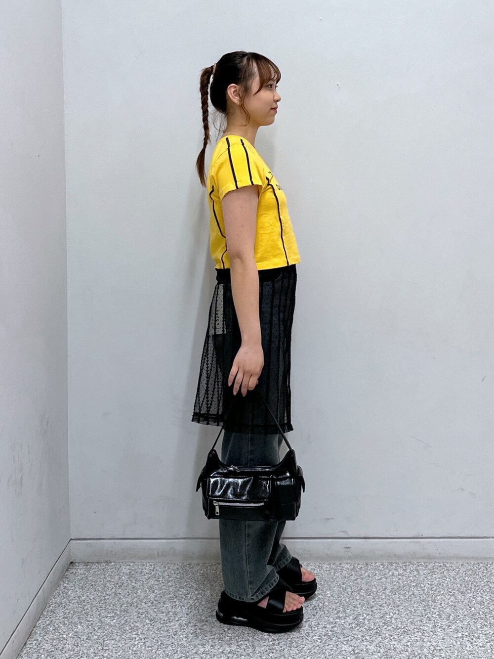 ブラック系のスカート、ブルー系のデニムパンツ、オレンジ系のTシャツ/カットソーを着用したレディースの秋コーディネートの3枚目の写真